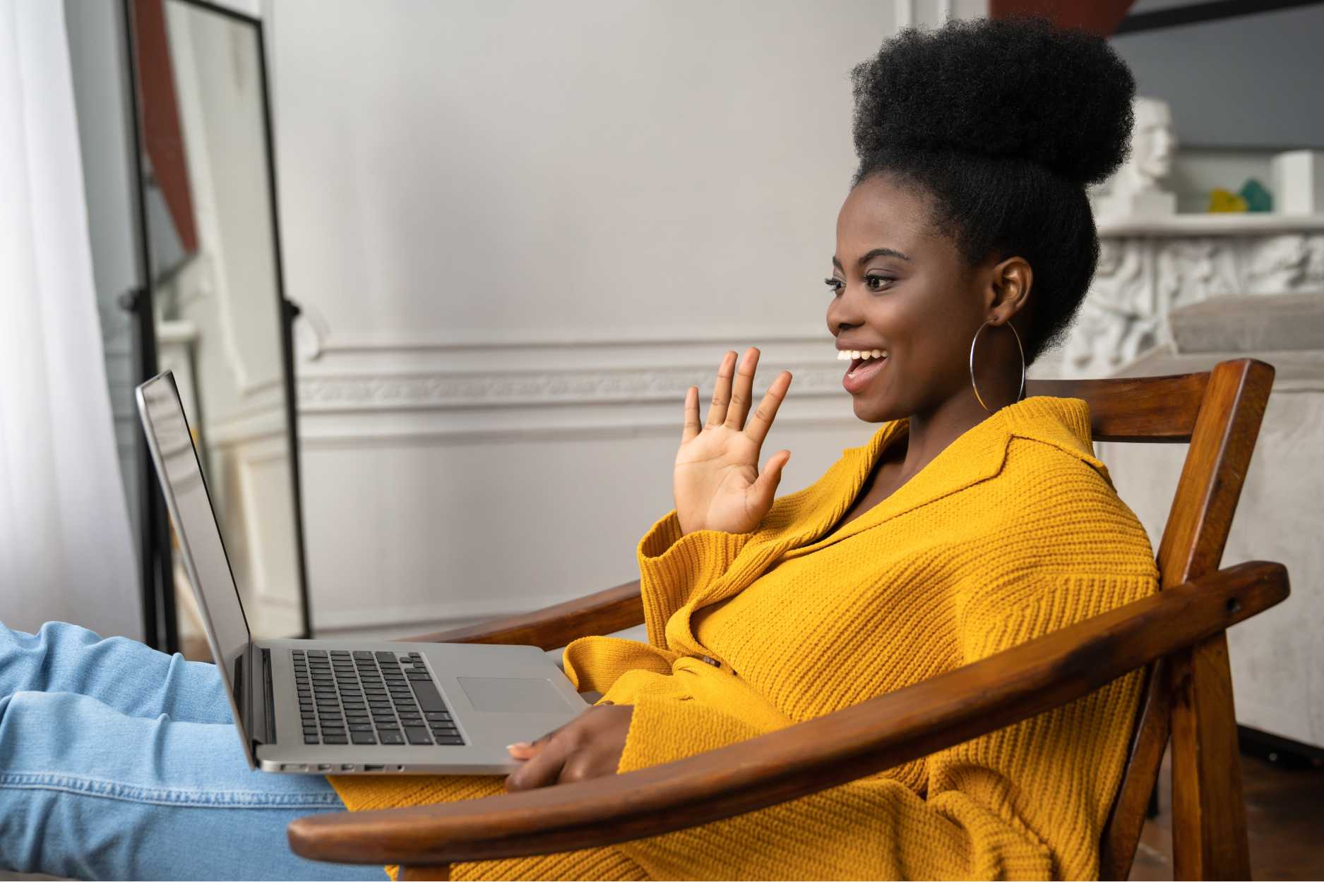 Black woman on the computer waving to her therapist to start an online therapy session with rowan center for behavioral medicine