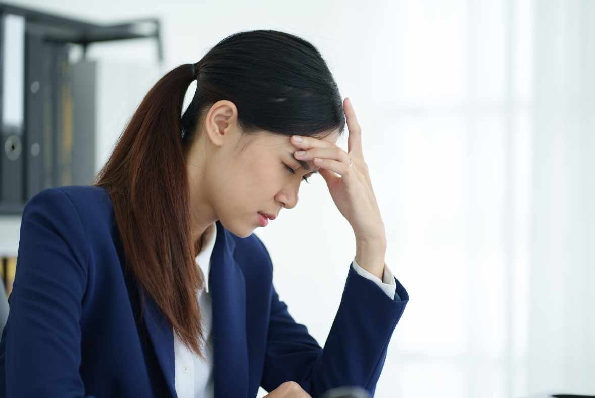 Chronic Stress affects physical health - woman with hand on head showing signs of dealing with chronic stress