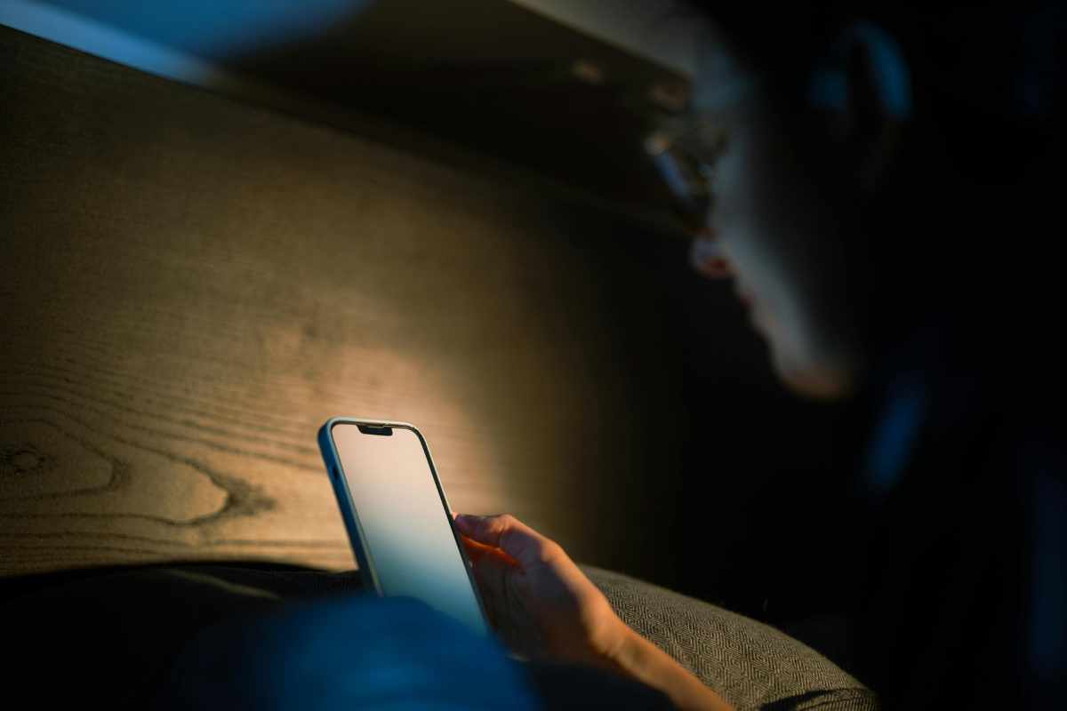 Person looking at phone showing the harmful effects of screen time blue light on sleep