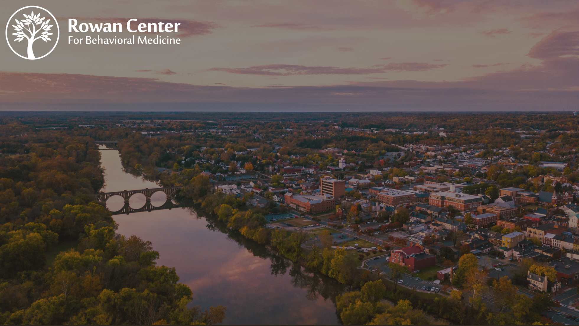 Rowan Center for Behavioral Medicine Virginia Location Hero Image - Overhead shot of Virginia with a quaint river and bridge