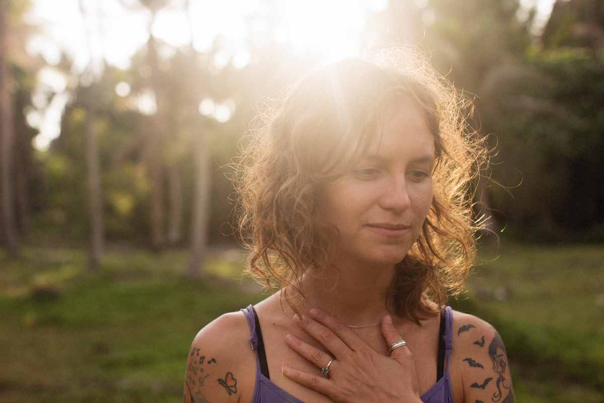 Woman with sunlight on her hair in the forest showing relief from Depression after therapy at Rowan Center for Behavioral Medicine