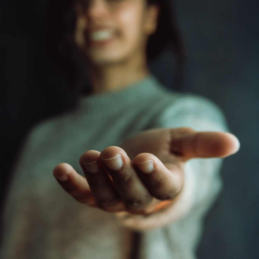 black woman reaching her hand out in support of anxiety treatment