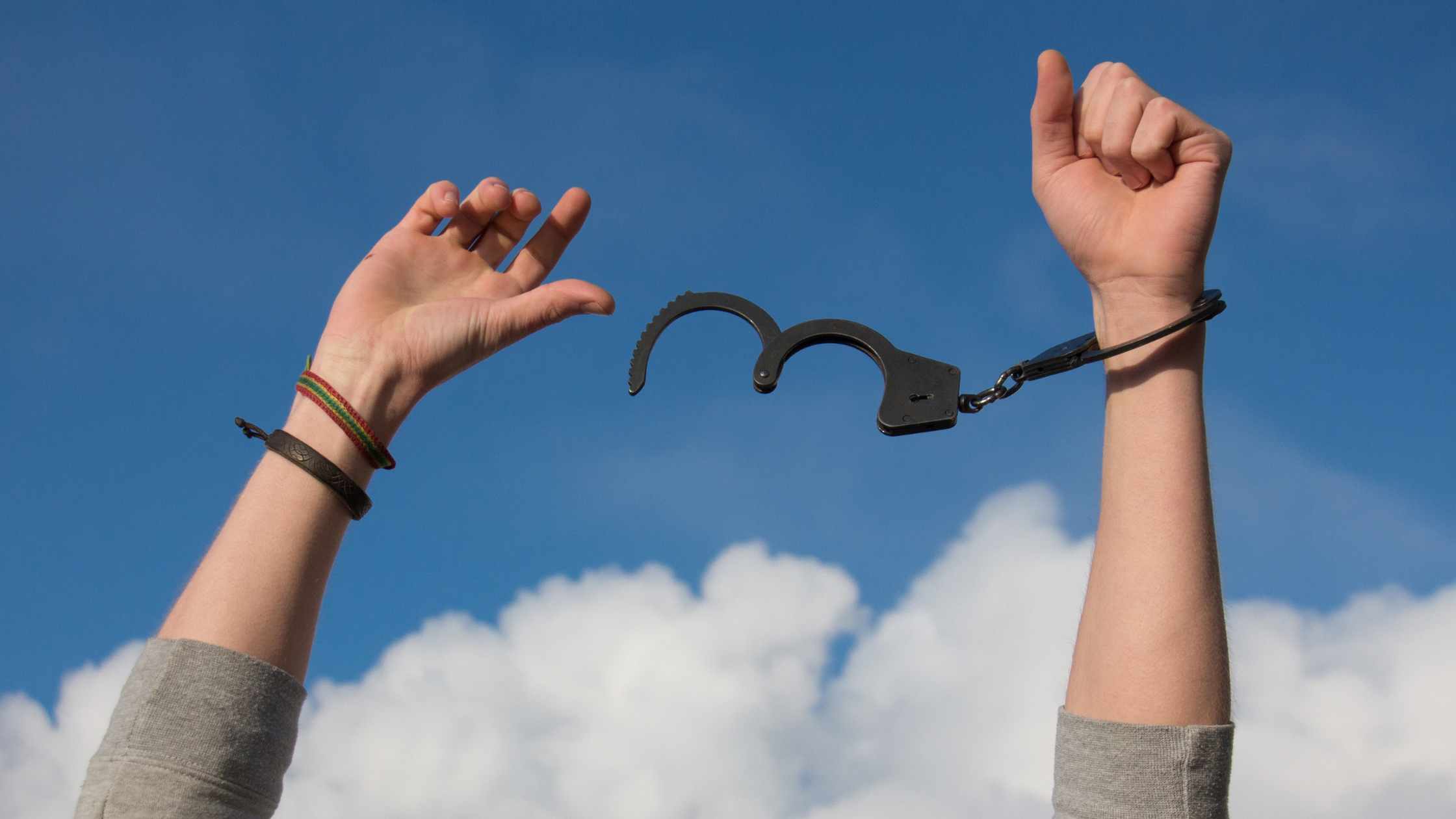 hands breaking free from handcuffs with clouds in sky the background symbolizing how therapy helps create relief from depression